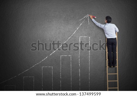 Business Man Standing On Ladder Drawing Growth Chart On Wall