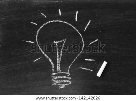 Drawing of a bulb idea on black board