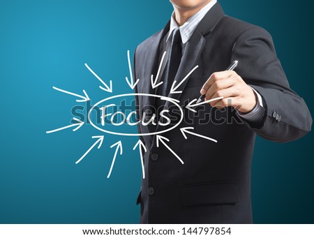 business man writing target on focus