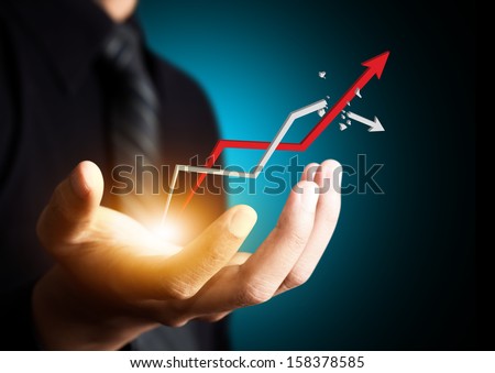 Hand holding a rising arrow representing business growth Hand holding a rising arrow representing business growth