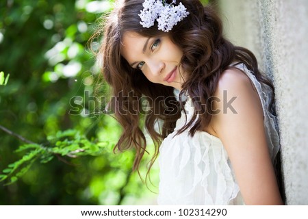 Beautiful girl with lilac flower in hair
