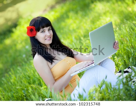Beautiful girl with laptop in the park
