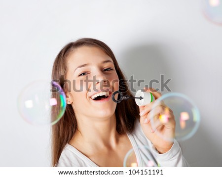 Girl making soap bubbles in studio