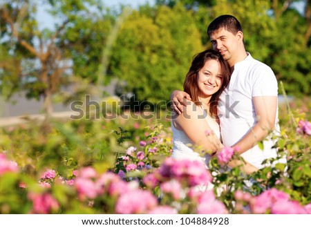 Men and women in rose flowers garden