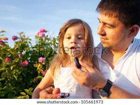 Father with daughter in rose flowers garden