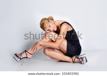 elegant lady in the black dress sitting on the floor. isolated on white
