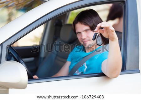 the guy sitting in the car with the keys in the hands