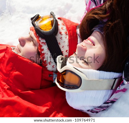 Girl and boy in snow mask lying on the snow