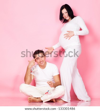 Pregnancy young woman with man in studio