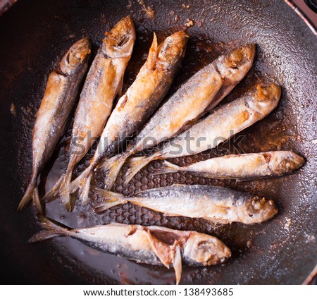 Fish frying on the pan in flour