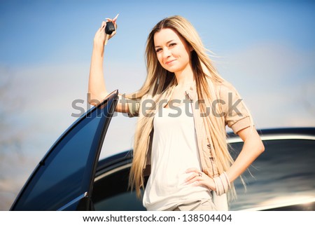 Beautiful young girl with car key in hand