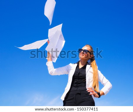Business woman throwing stack of papers in the air