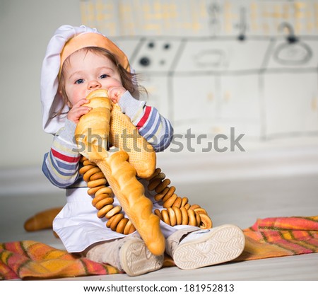 Little boy in baker costume with long loaf