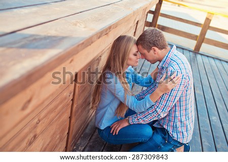 Young couple outdoor portrait. Beautiful pretty girl kissing handsome boy. Sensual photo