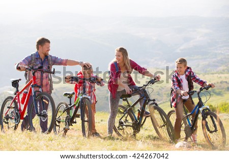Family of four people riding bikes in the mountains