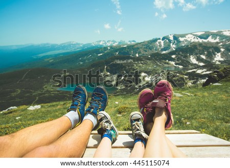 Legs of traveler family sitting on a high mountain. Freedom concept