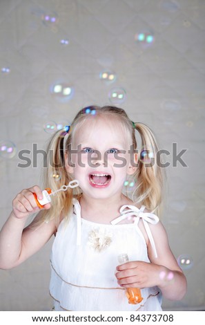 Girl with soap bubbles in studio