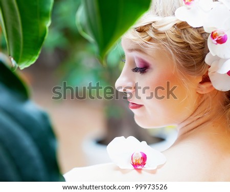 Beautiful girl with orchid flower in hair
