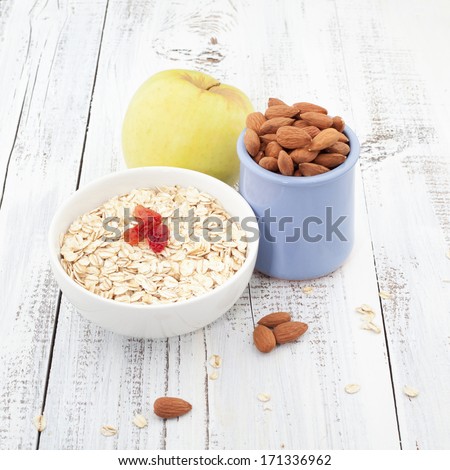 Breakfast with apple, oat and almond with cup of tea on wooden table