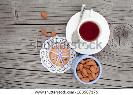 Breakfast with fresh chocolate homemade cookies and almond with cup of tea on wooden table