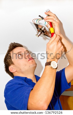 Electrician installing lamp in home addition
