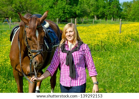 Young woman in nature leading her horse