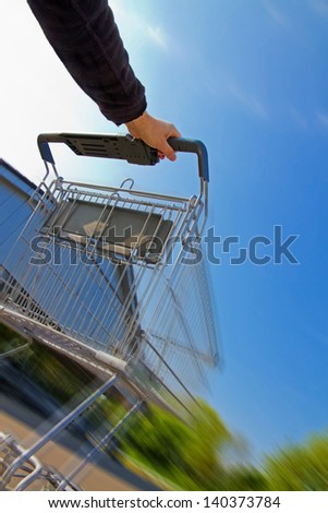 Speed shopping - Man with  shopping cart, motion blur