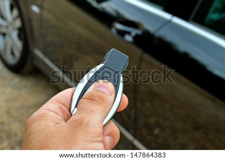 Men\'s hand presses on the remote car of his car