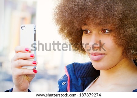 Girl with afro hair cut making a selfie
