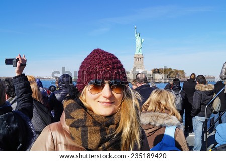 Young woman in New York, in background the statue of liberty