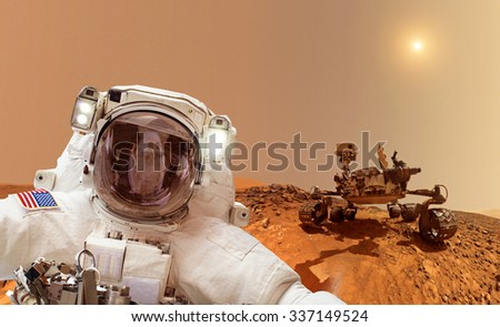 Astronaut on Mars in background a rover - Elements of this image furnished by NASA