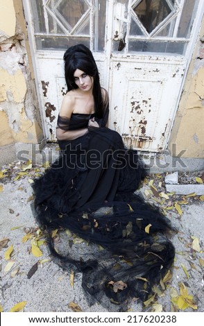 Mysterious woman dressed in black gothic dress.