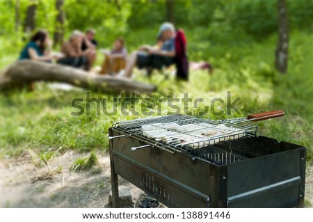 Family resting in nature and is preparing on the grill