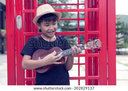 Asian boy playing ukulele and sing song