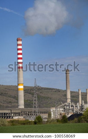Factory with smoke on blue sky