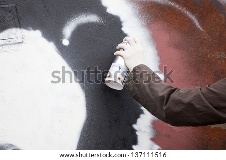 Graffiti artist draws on the wall