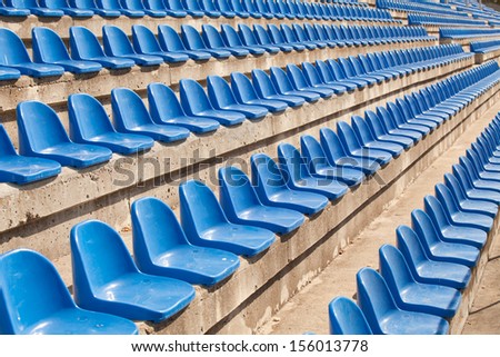 empty plastic blue seats on football stadium