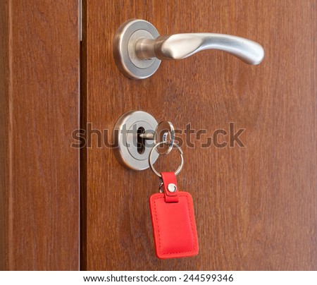 door handle with inserted key in the keyhole with red keyholder
