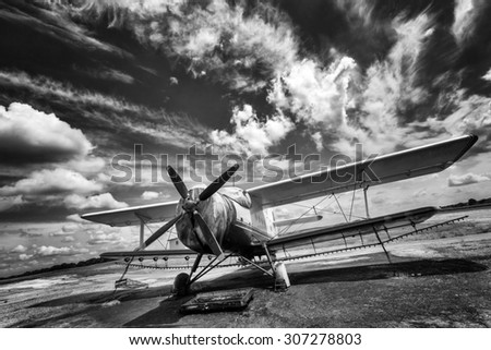 Old airplane on field in black and white