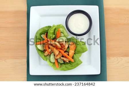 Buffalo chicken lettuce wrap, with spicy chicken, cucumbers, carrots, lettuce and dipping sauce.