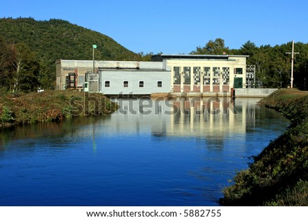 a view of a hydro electric power station with reflection in river water