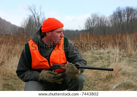 A man hunting with gun in field