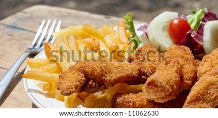 Chicken finger dinner with french fries and salad.