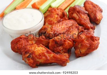 Buffalo chicken wings appetizer plate with blue cheese, celery, and carrots.