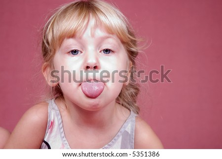 A little blond girl sticking out her tongue