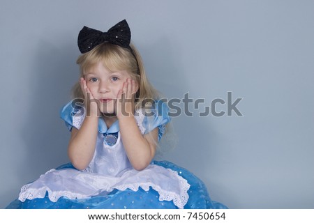 A surprised girl in Alice in Wonderland costume