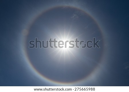 A bright 22 degree halo around the sun - a rainbow-like phenomenon caused by light refracting