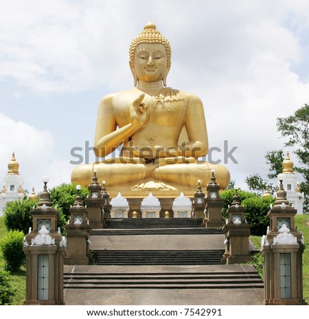 stock photo : A sitting Buddha statue against a blue sky.