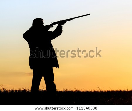 Silhouette of man with rifle aiming the hunt during a hunting party