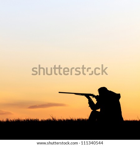 Silhouette of man with rifle aiming the hunt during a hunting party